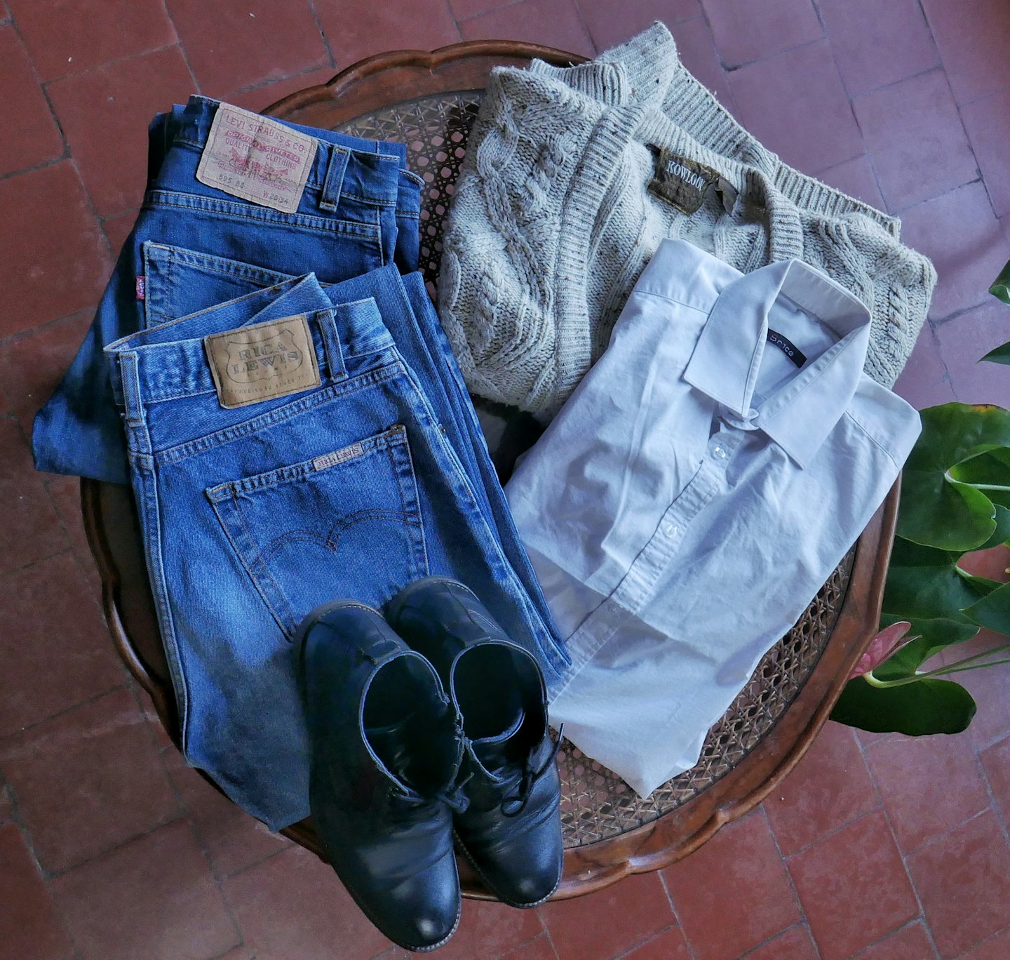 Men's clothing and accessories arranged neatly on a wooden table.