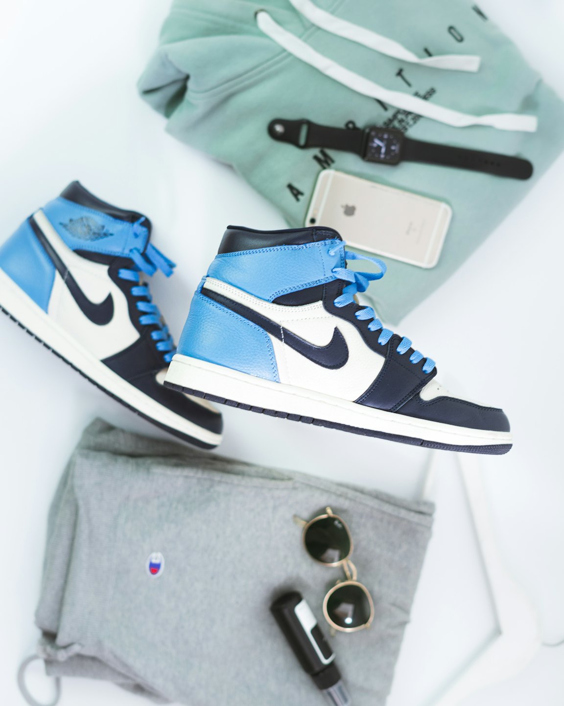 Sneakers and modern tech accessories laid out on a white surface.